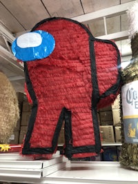 a red and blue elephant pinata is on display in a store