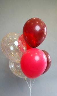 a bunch of red and gold balloons on a stick