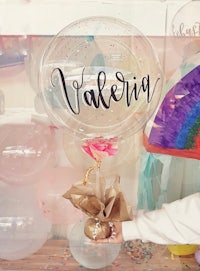 a person holding a balloon with the word valencia written on it