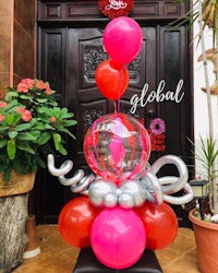 a pink and silver balloon arrangement in front of a door