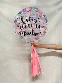 a person holding up a balloon with the words'feliz da de madre'