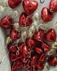 many red and gold heart shaped balloons in a box