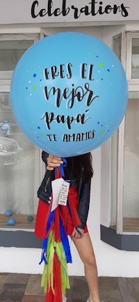 a woman holding up a balloon with the words'fres el mejor pa'