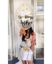 a woman holding a balloon that says te amo amor