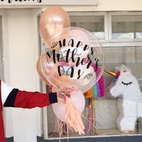 a woman holding a balloon with the word mother's day