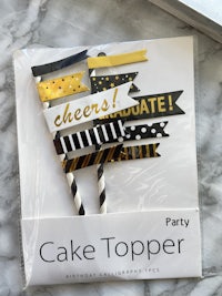 a cake topper with black and yellow stripes on it