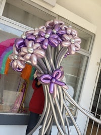 a balloon bouquet with purple and silver flowers