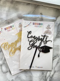 a cake topper with the word 'graduation' on it